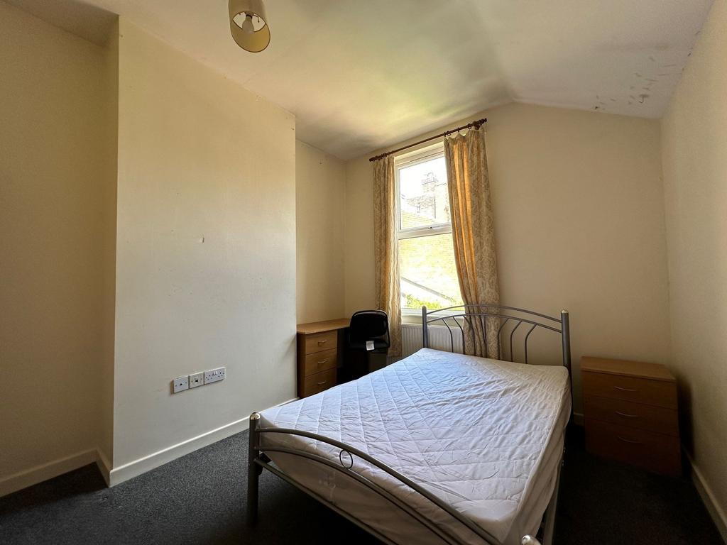 Bright double bedroom with a metal bed frame, n...