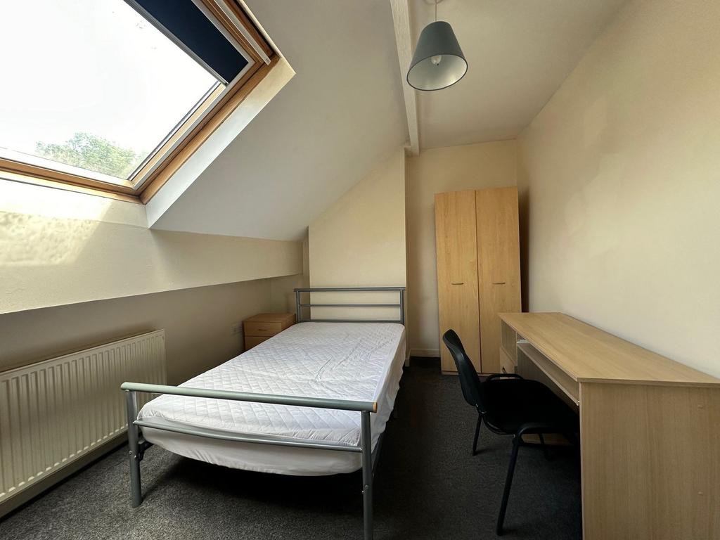 Bright attic single bedroom with a large skylig...