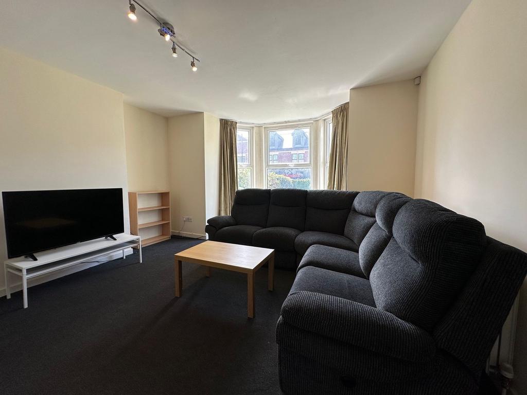 Bright bay-front living room with a large, comf...