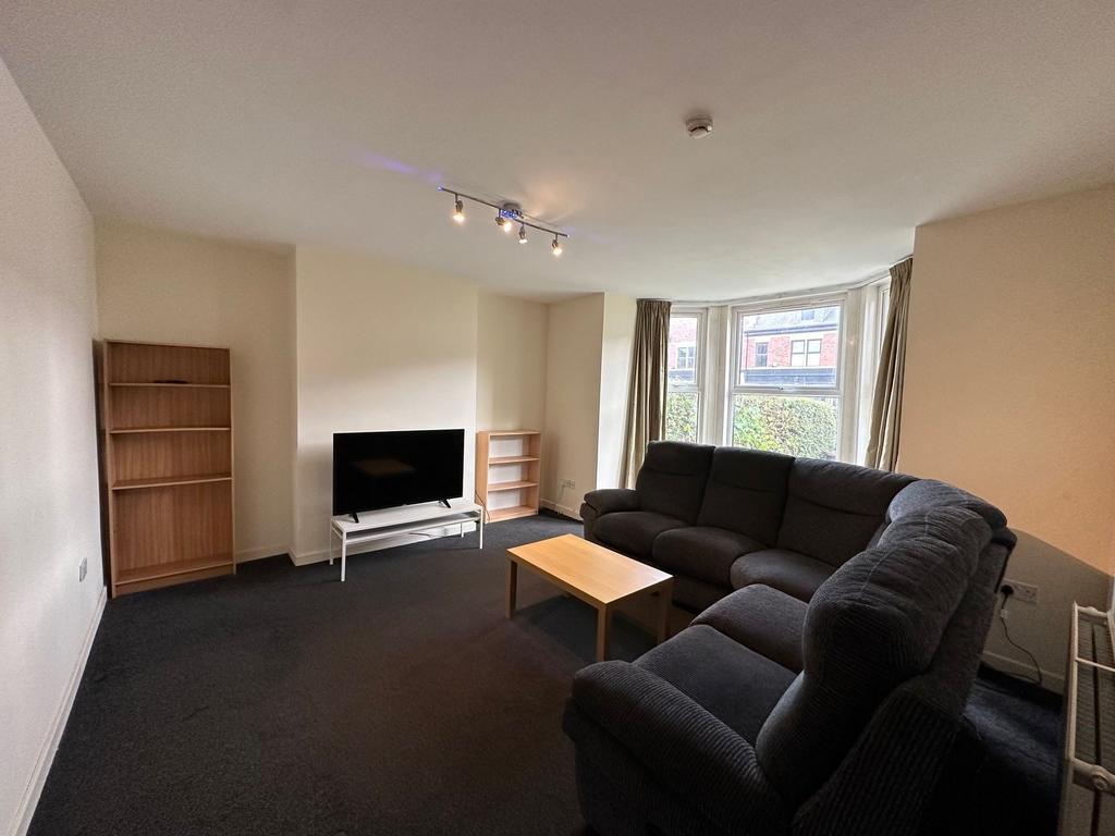 Bright, spacious living room with a large bay w...