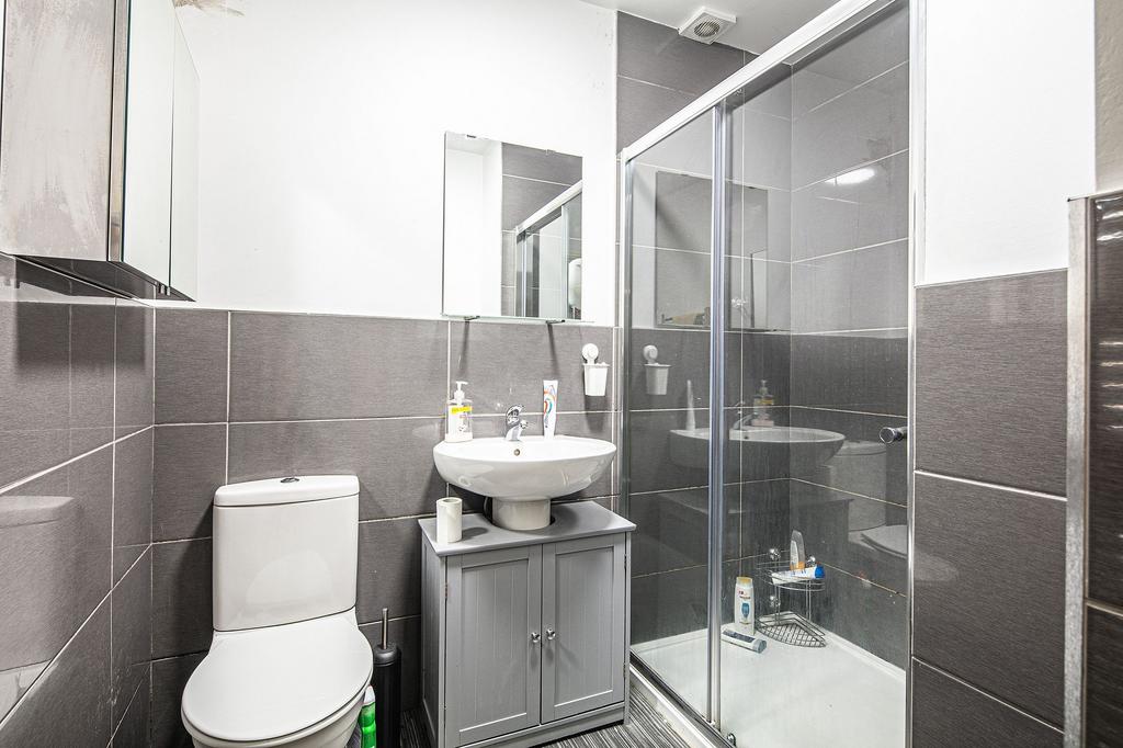 Modern tiled bathroom with a walk-in shower, pe...