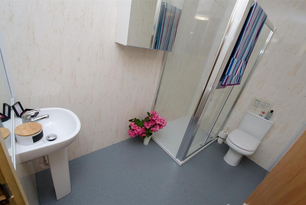 Bright, modern bathroom with a corner shower cu...