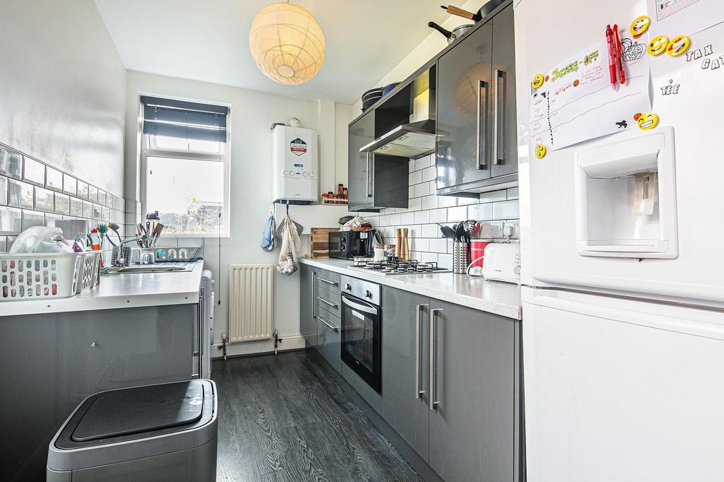 Bright modern galley kitchen with glossy grey c...