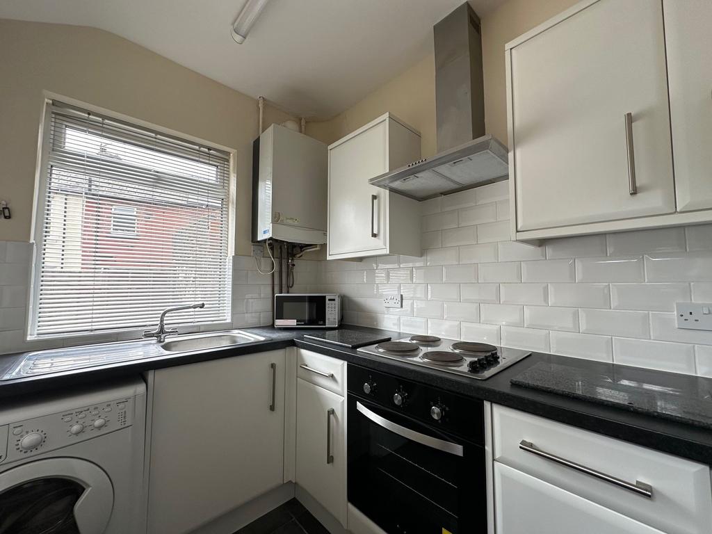 Bright, modern kitchen with white cabinetry, bl...