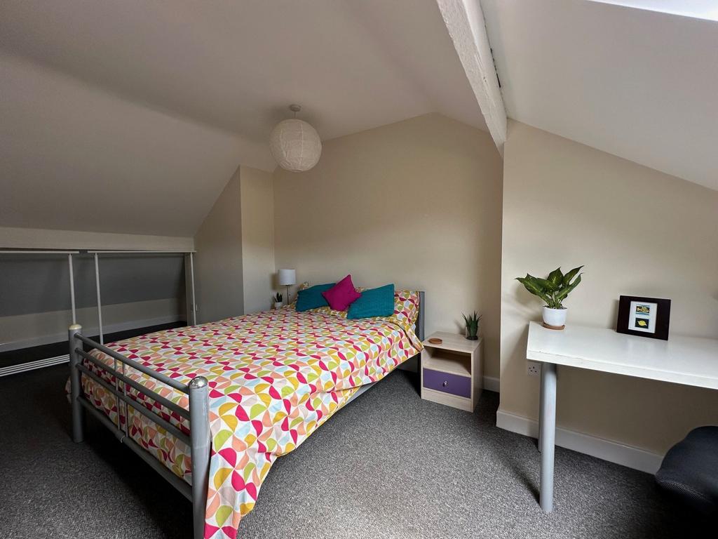 Bright, neatly styled bedroom in a loft room wi...