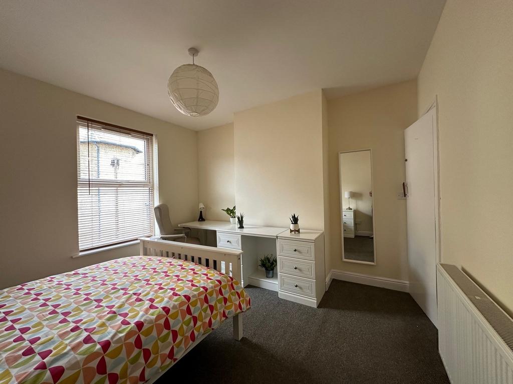 Bright, neutrally decorated double bedroom with...