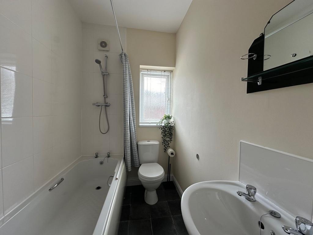 Bright, modern bathroom with a combined bath an...