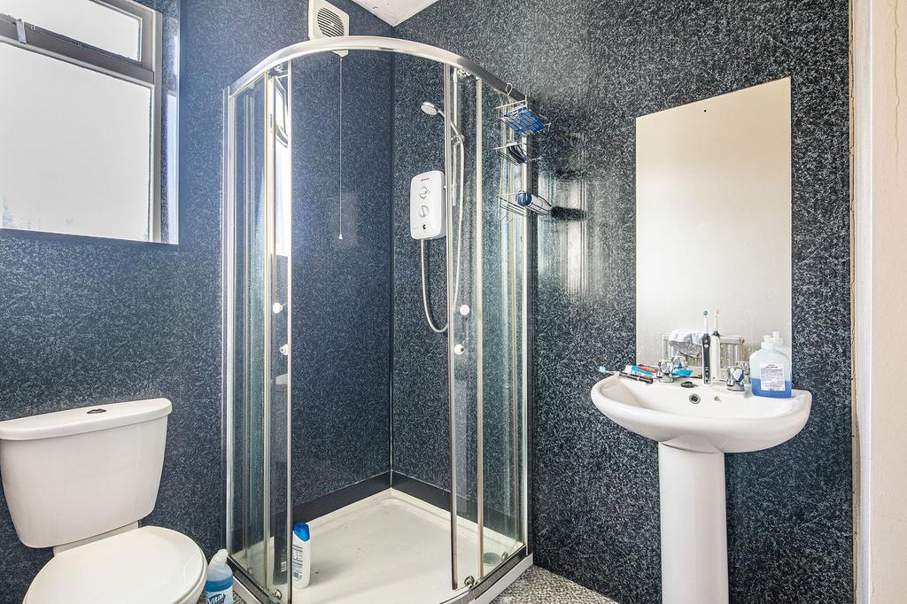 Bright, modern bathroom with a corner glass sho...