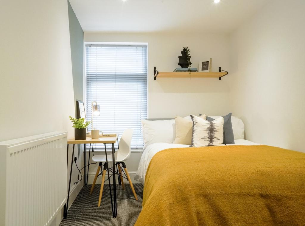 This cozy double bedroom features a comfortable...