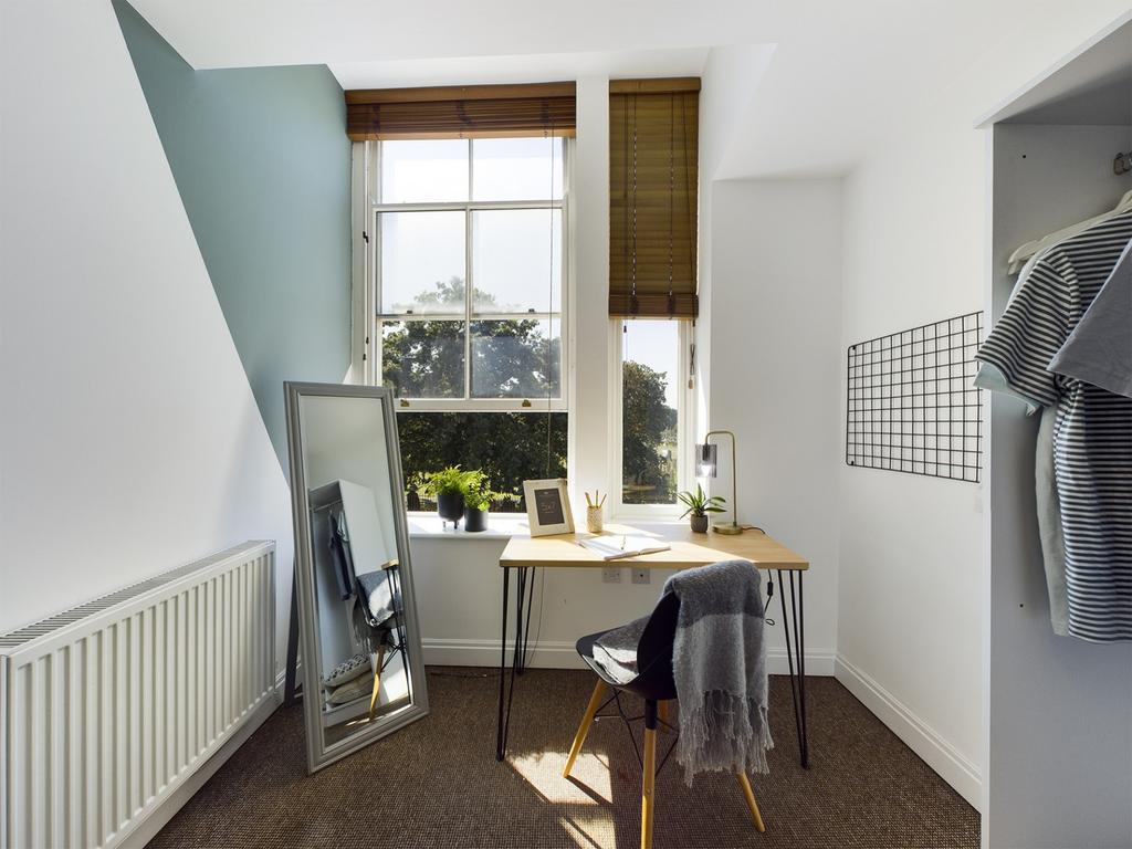 A bright and inviting double bedroom with a sty...