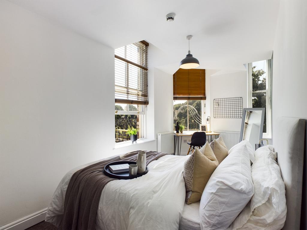 A bright and inviting double bedroom with styli...