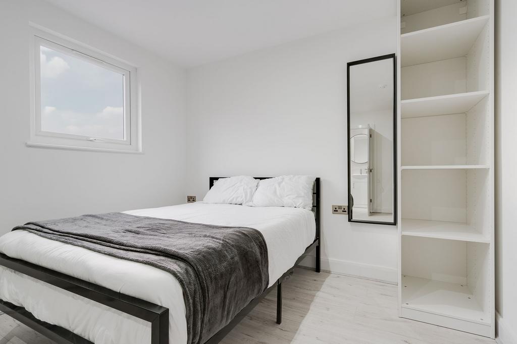 A bright and minimalist single bedroom with a n...