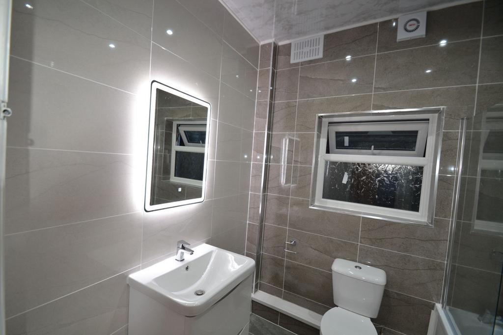 Modern, well-maintained bathroom featuring neut...