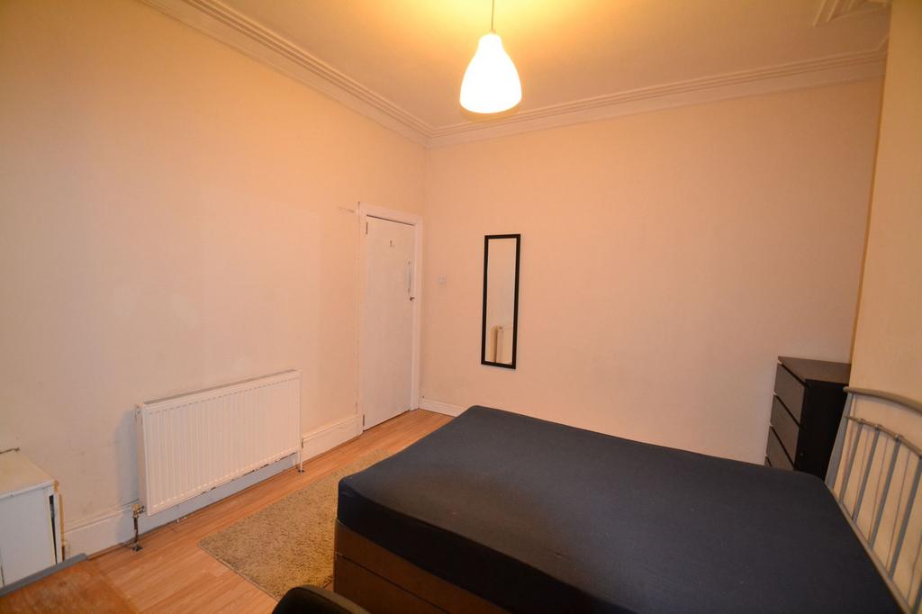 A well-lit, cozy bedroom featuring a double bed...