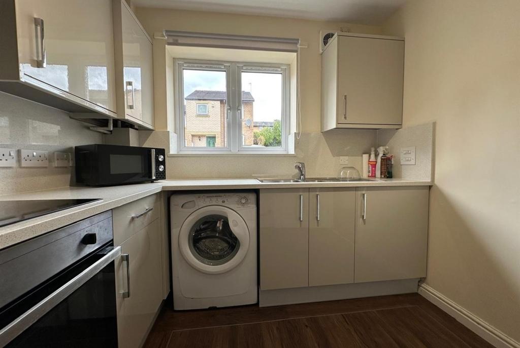 Modern fitted kitchen with gloss cabinets, inte...