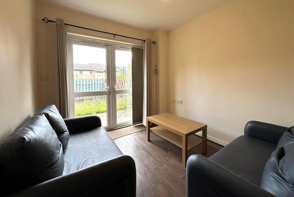 Bright ground-floor living room with patio door...