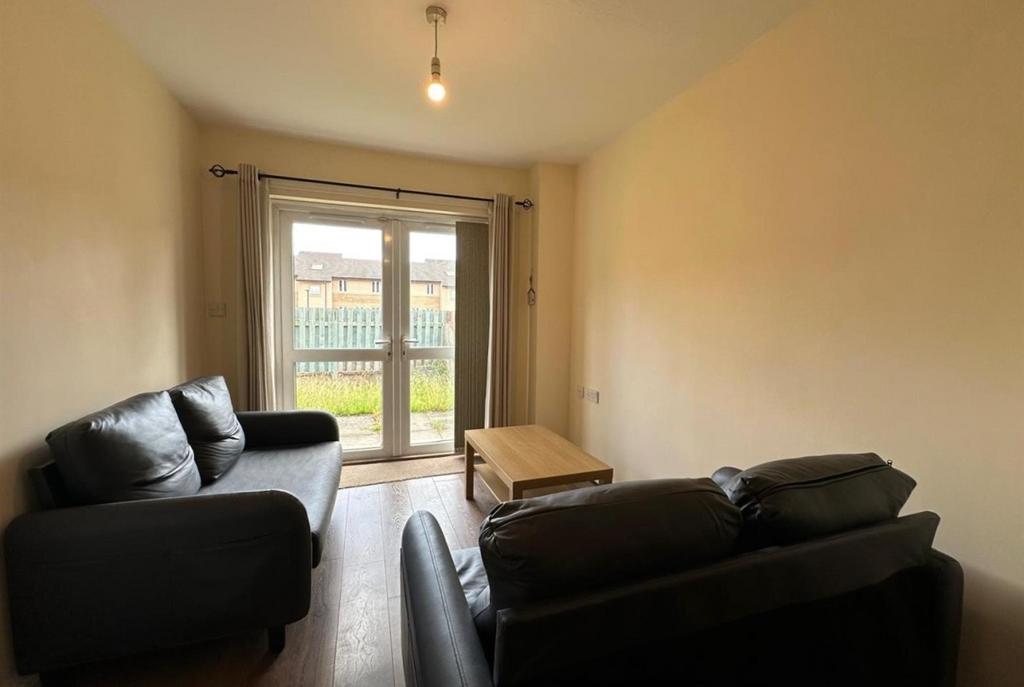 Neat living room with two comfortable leather s...