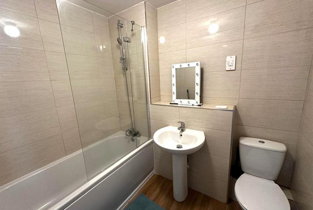 Modern tiled bathroom with a bathtub and overhe...