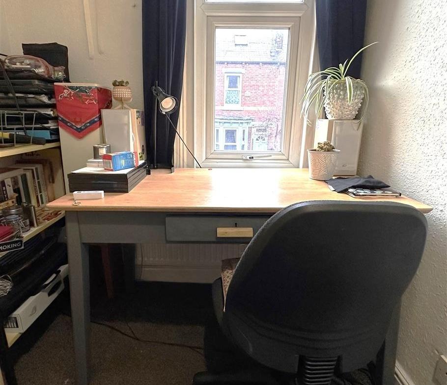 Well-lit workspace by a window with a wooden de...
