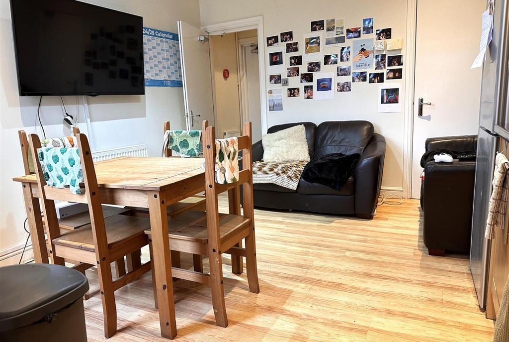 Bright, well-kept communal lounge with a wooden...