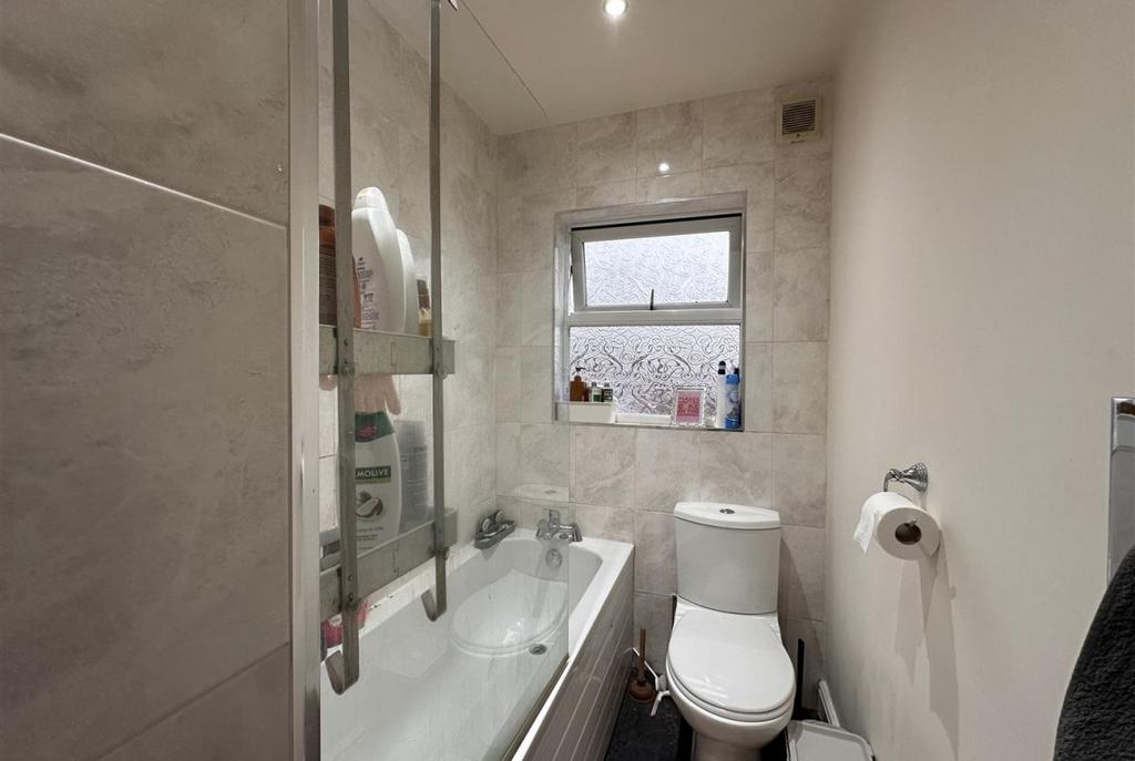 Modern tiled bathroom with a bathtub and glass ...