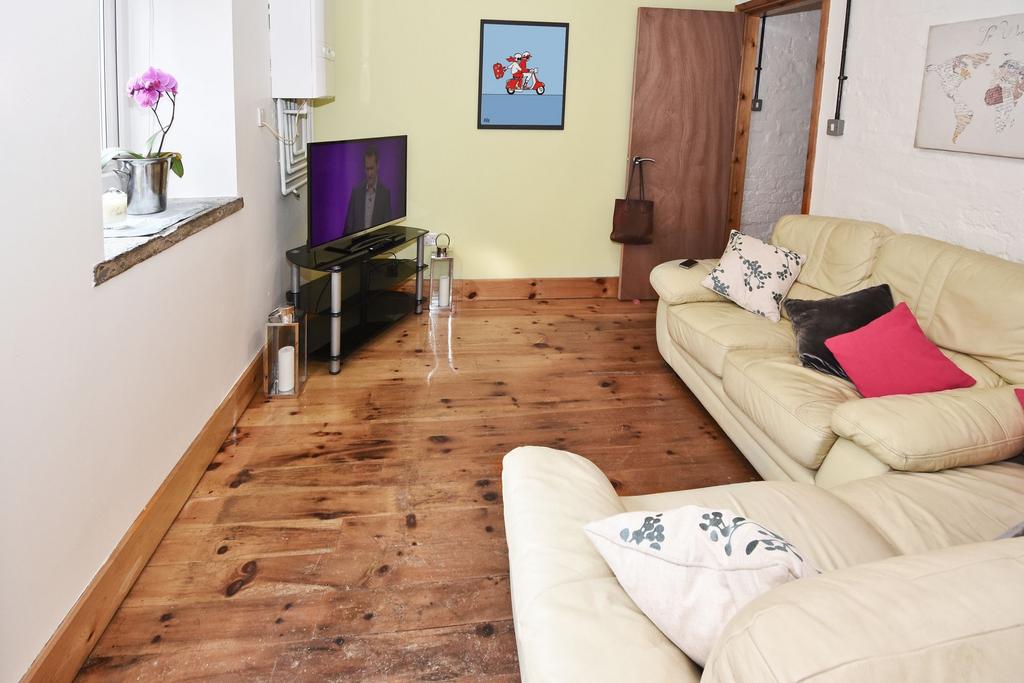 Bright, cosy living room with warm wooden floor...