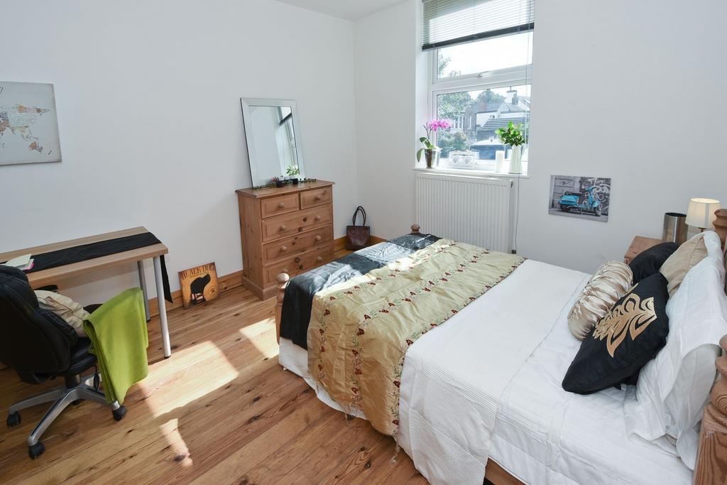 Bright, neatly furnished bedroom with a double ...