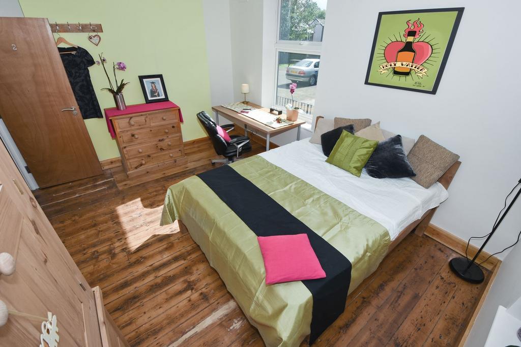 Bright, stylish bedroom with wooden floors, a c...