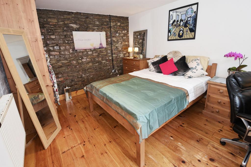 Bright, well-styled bedroom with exposed brick ...