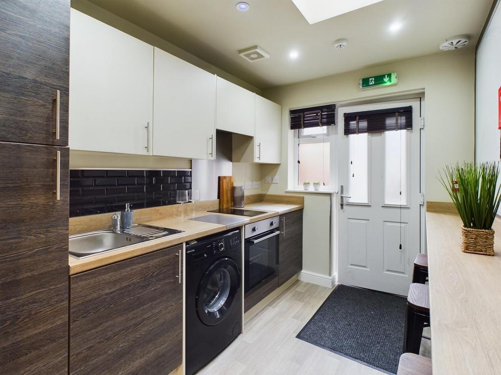 A modern and clean kitchenette with ample stora...