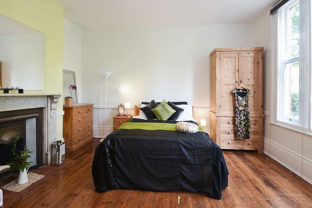 Bright, stylish bedroom with wooden floors, a c...