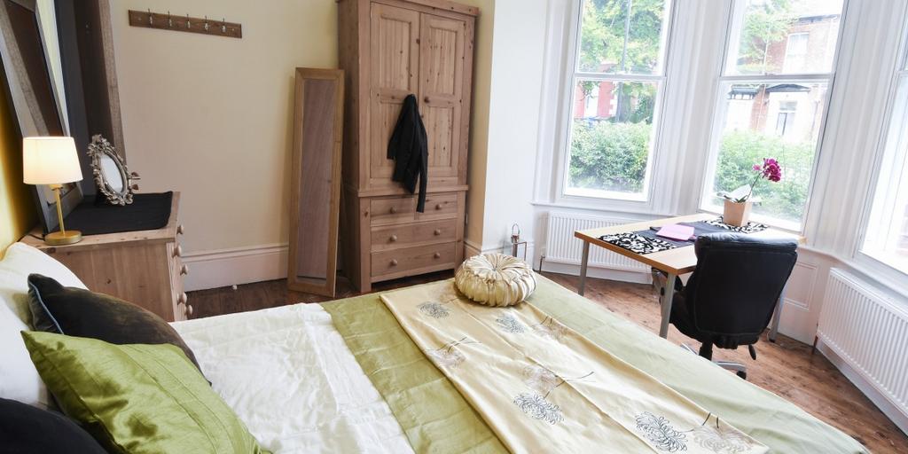 Bright, well‑kept master bedroom with large bay...