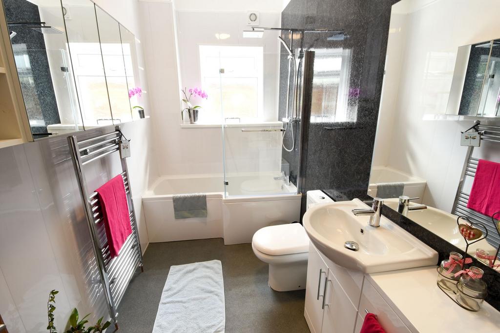 Bright, modern bathroom with a combined bath an...
