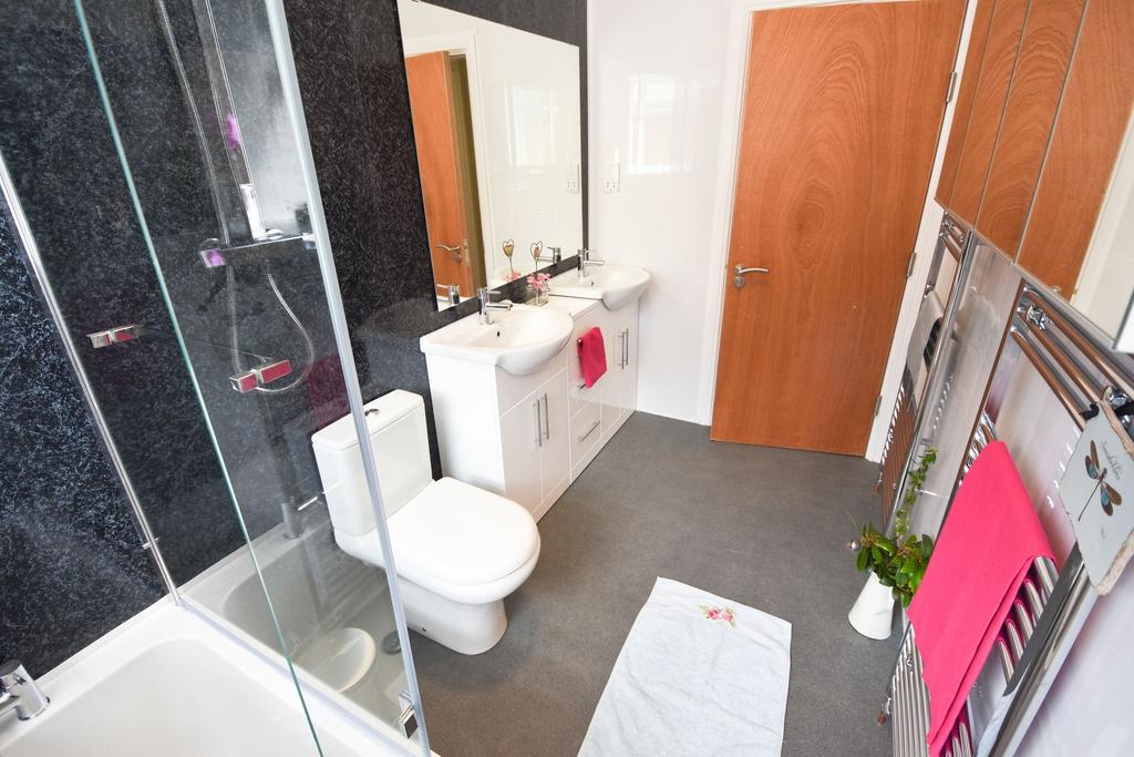 Modern bathroom with a double vanity, glass-enc...