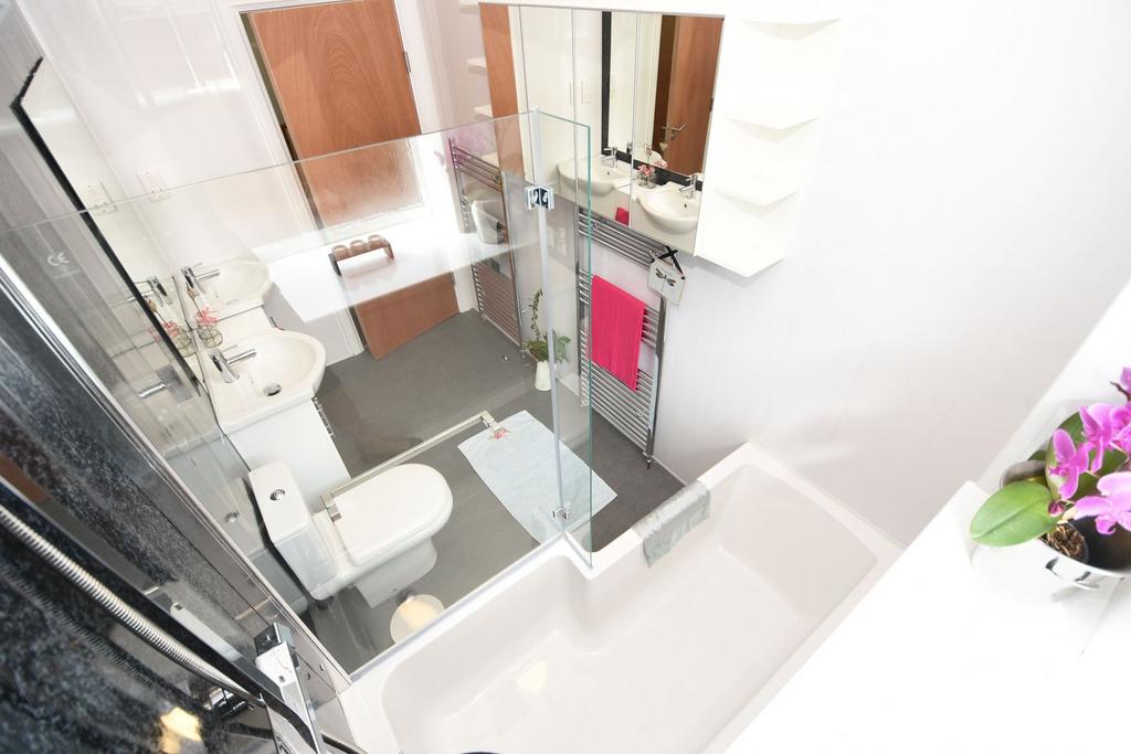 Bright, modern bathroom with a bathtub and show...