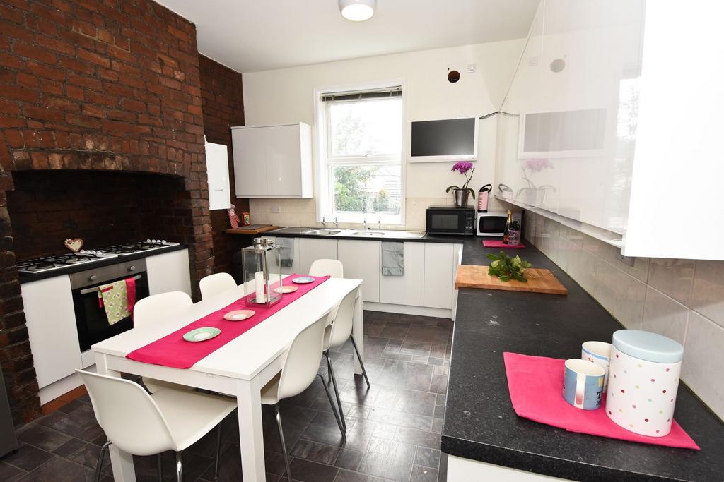 Bright, modern kitchen with white cabinets, a d...