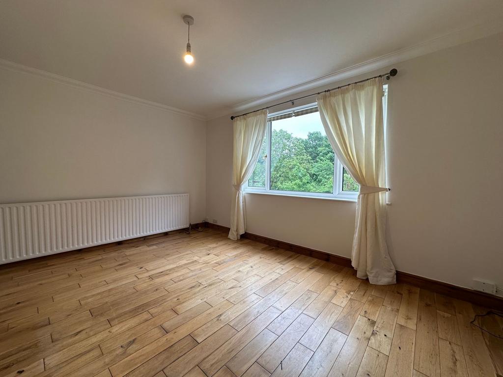 Bright, unfurnished bedroom with wide window ov...