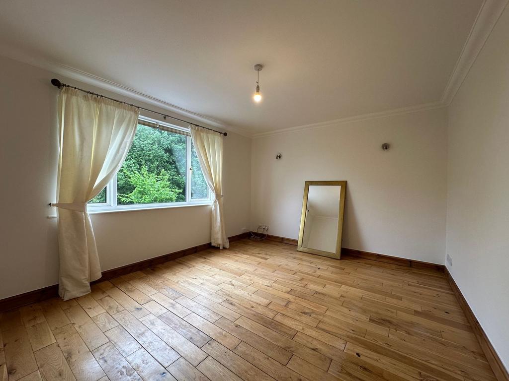 Bright, empty bedroom with large window framing...