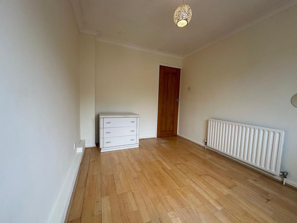 Bright, neutral single bedroom with light wood ...