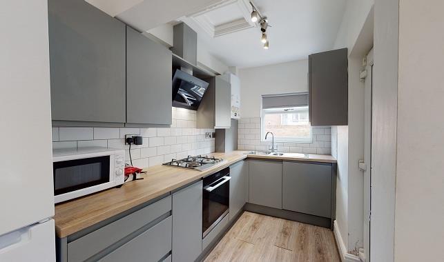 Modern galley kitchen with grey fitted cabinets...
