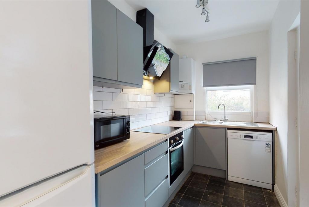 Modern galley kitchen with grey cabinets, integ...