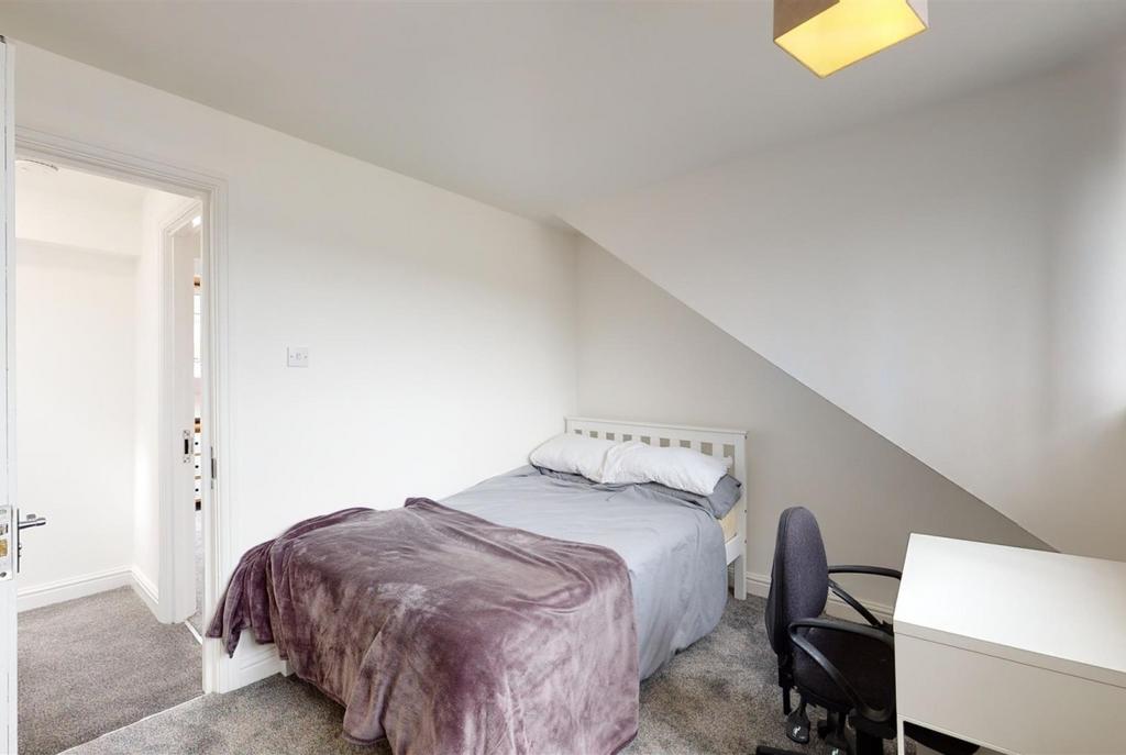 Bright, neutral bedroom with a comfortable sing...
