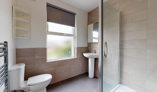 Bright, modern bathroom with large frosted wind...