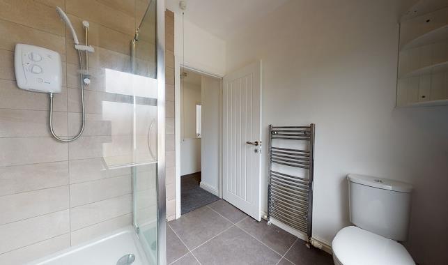 Modern bathroom with walk-in shower, chrome hea...