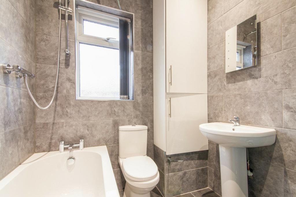 A modern bathroom featuring elegant grey tiles,...