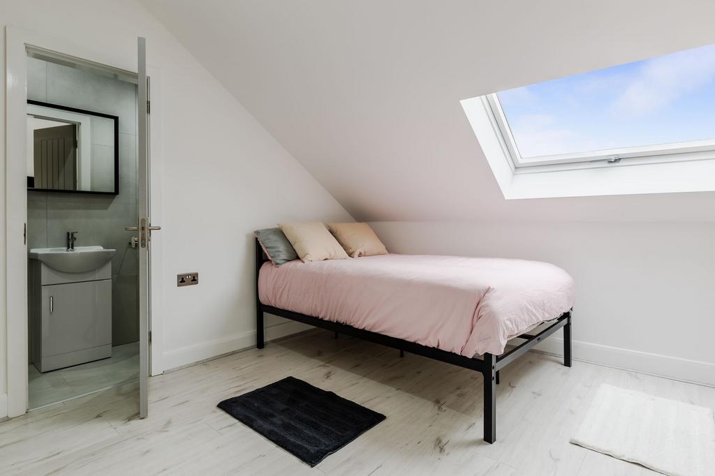 Bright and cozy single bedroom with soft pink b...