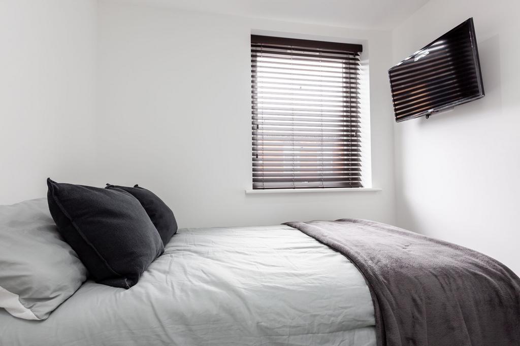 A modern and tidy bedroom featuring a neatly ma...