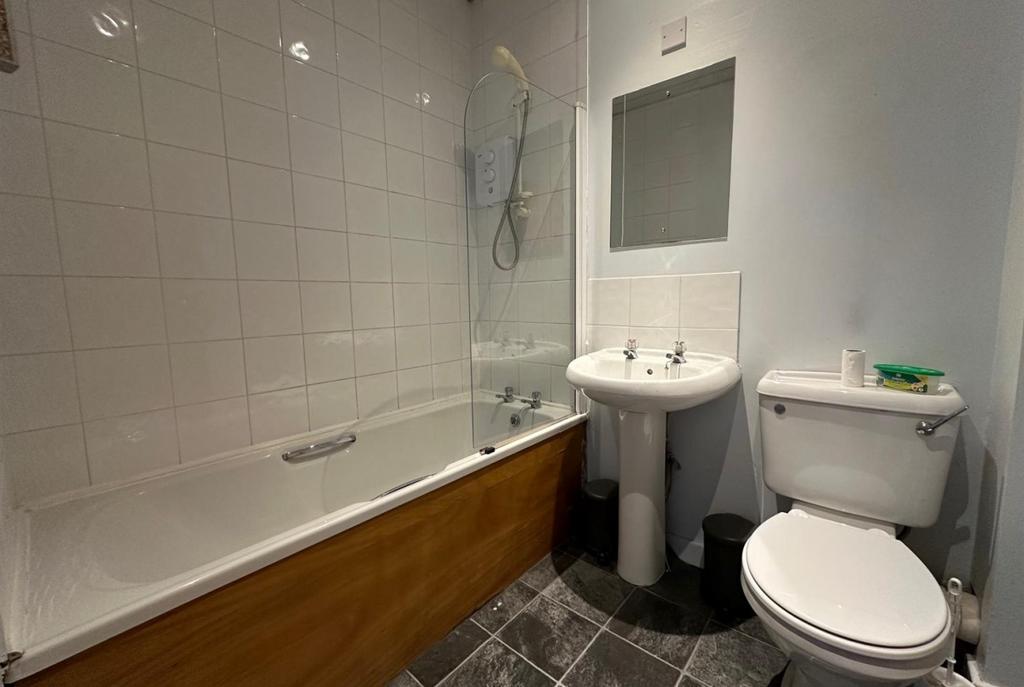 Neat three-piece bathroom with a white bathtub ...