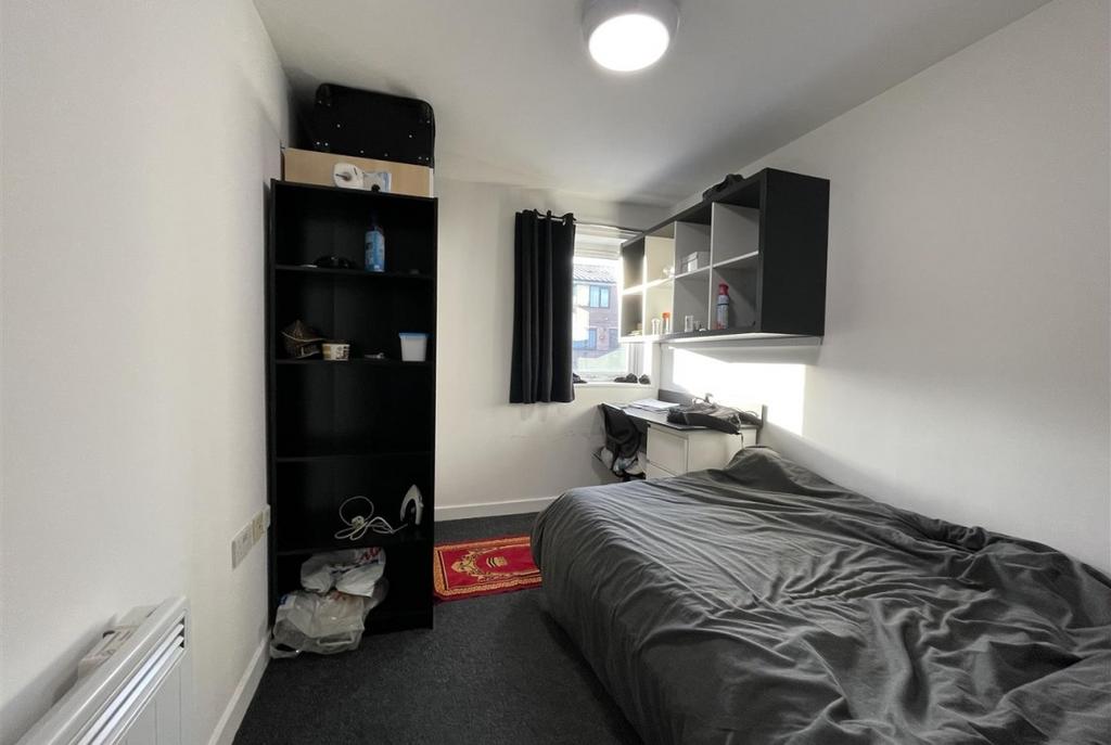 Bright, simply furnished single bedroom with a ...