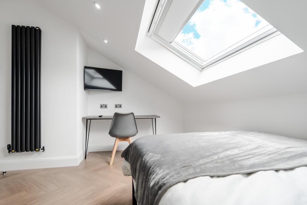 A bright and spacious master bedroom with a lar...
